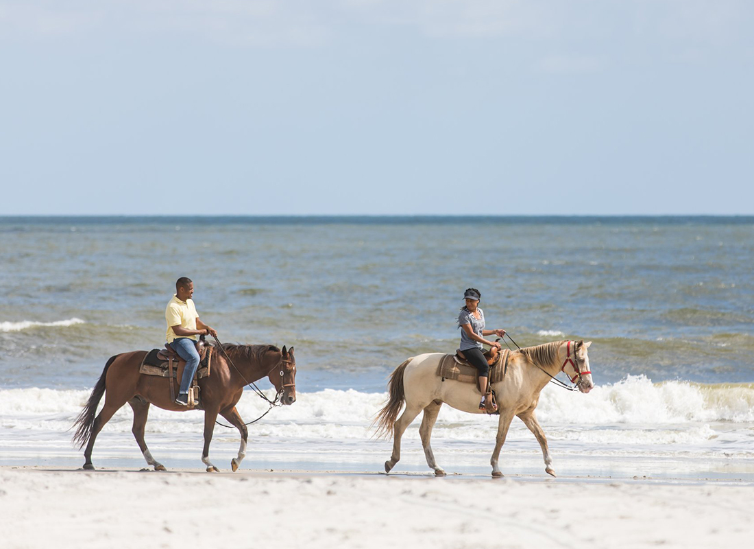 Personal Insurance - Two People Horseback Riding on a Beach